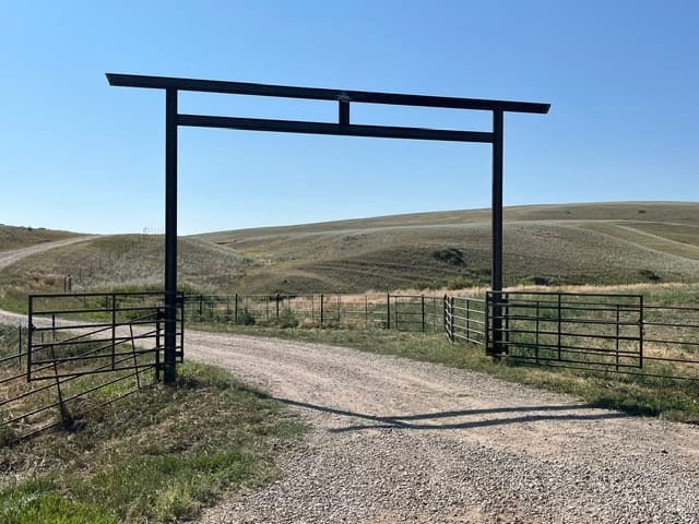 Black archway ranch gate rolling hills